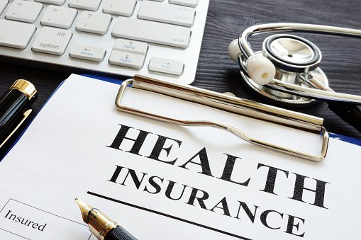 Individual health insurance policy and stethoscope. Insurance forms with a stethoscope
